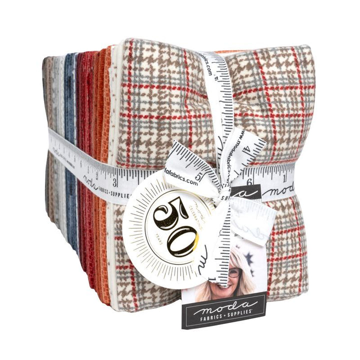 Pack of fabric strips with a measuring tape and Moda label on a white background