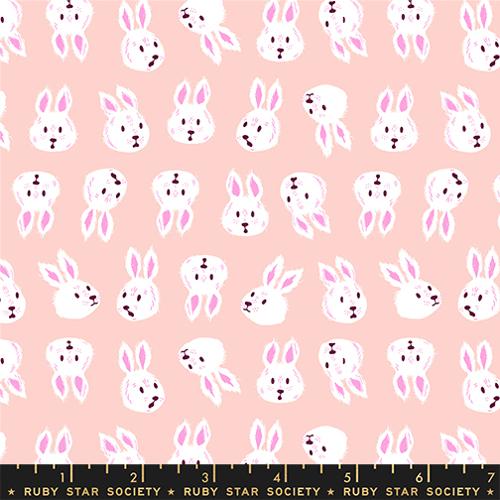 print featuring white rabbit heads with various facial expressions and in various orientations on a light pink background