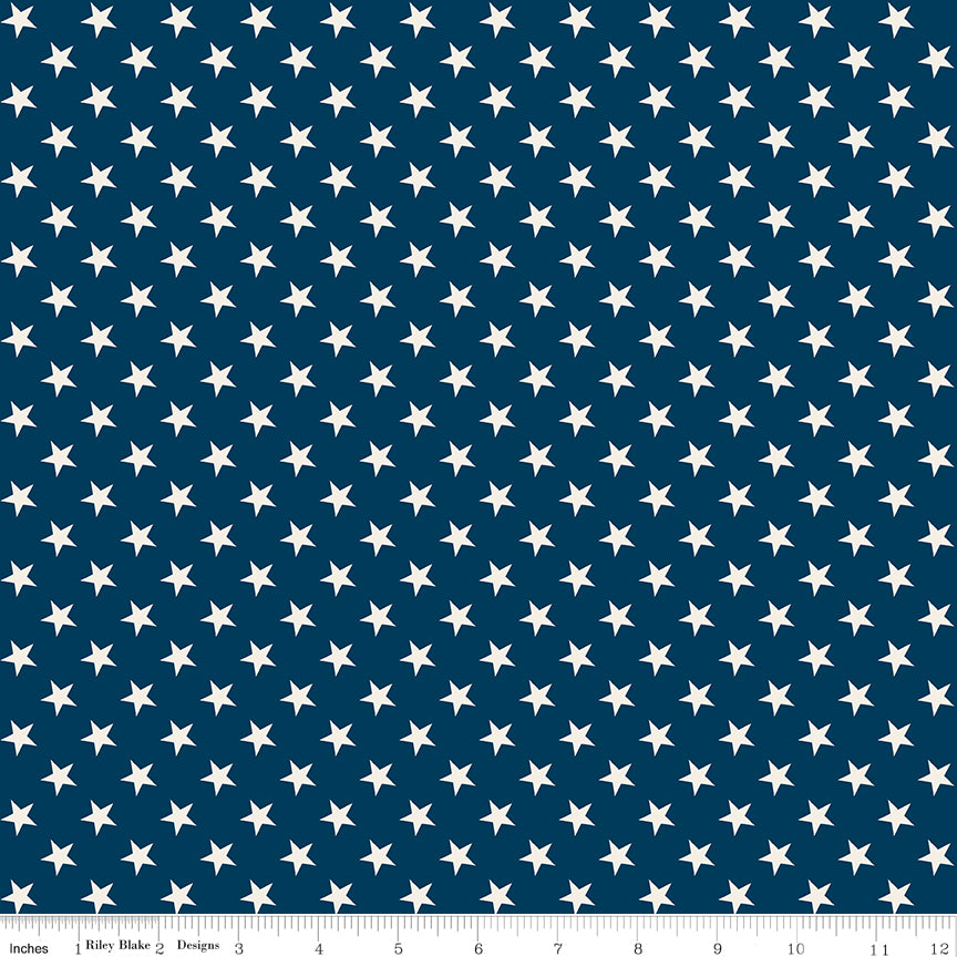Fabric with white stars pattern on a blue background, featuring a ruler at the bottom.