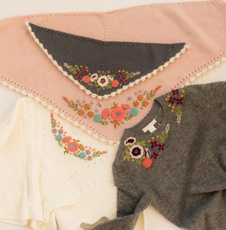 Embroidered floral patterns on a pink and gray fabric background