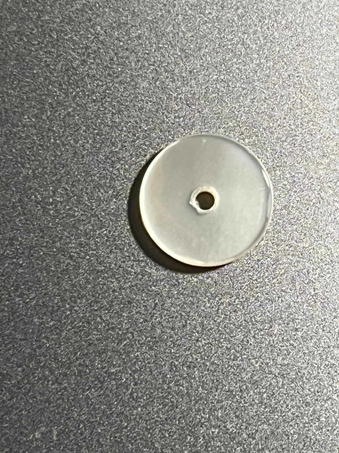 round one hole button on grey surface