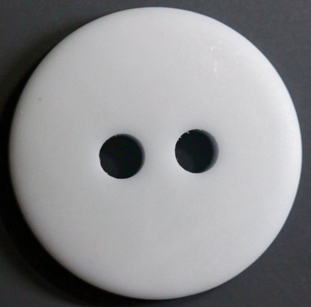 white 2 hole button on a dark background