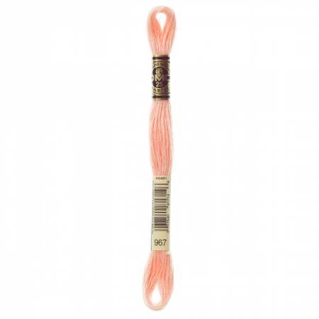 A skein of DMC floss in Very Light Apricot color, with the number 967 labeled on the packaging.