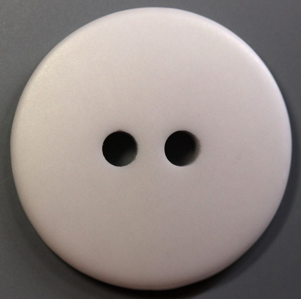 Close-up of a gray button with two holes on a gray background