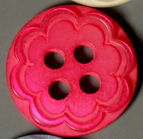Pink floral-patterned button on a gray background