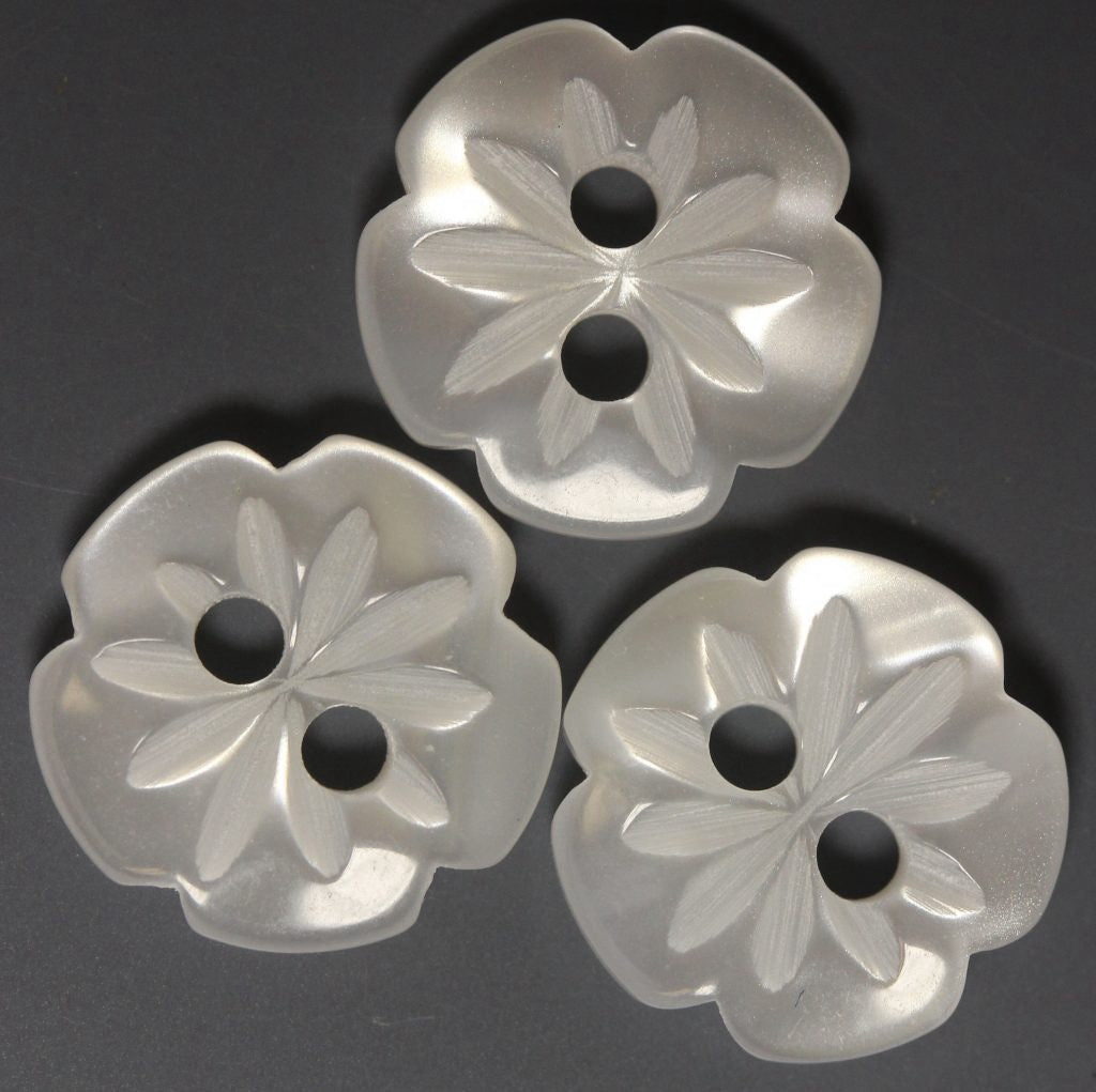Three floral-patterned buttons on a dark background