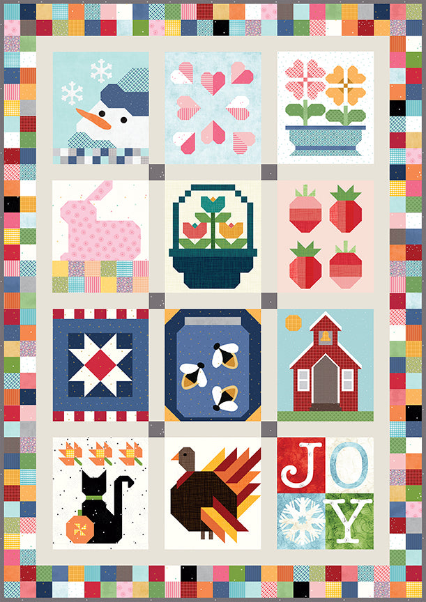 A colorful quilt-style tabletop banner featuring various designs for each month of the year, with a keepsake box at the bottom.