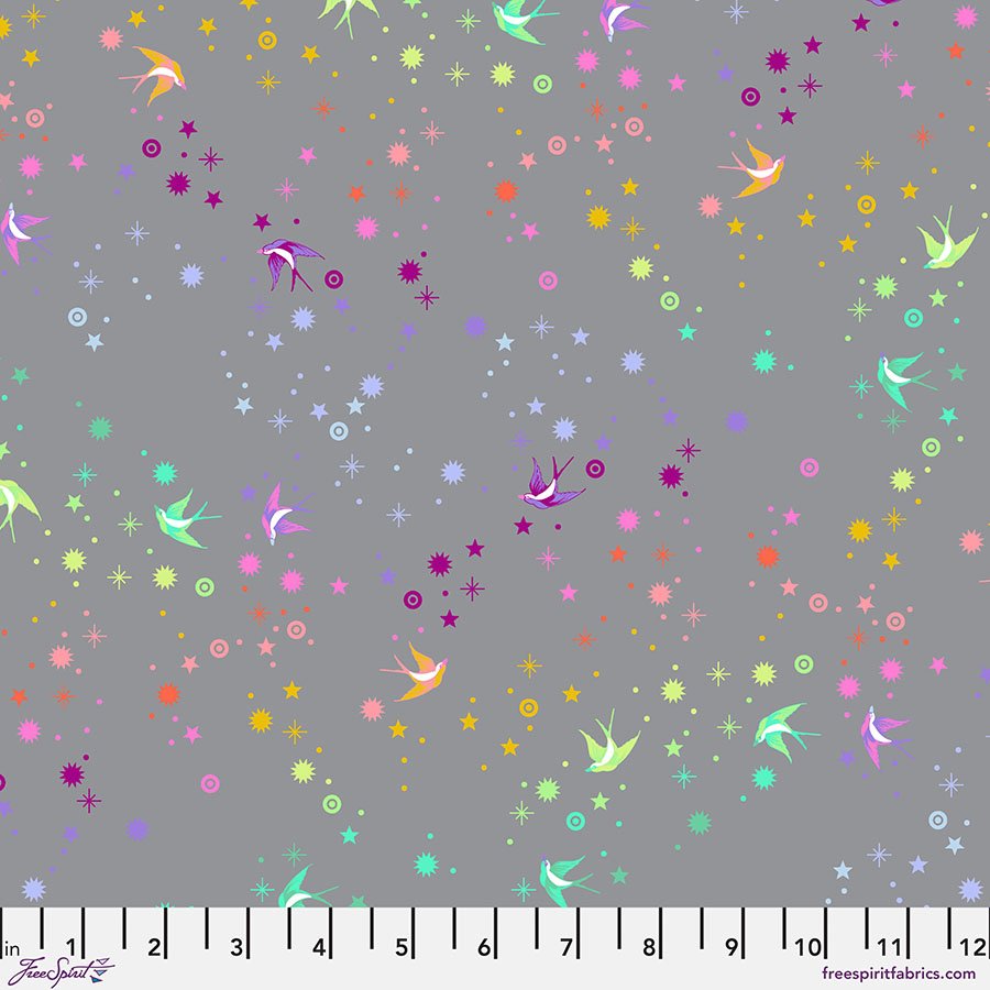 fabric swatch with a medium gray background with various small shapes of stars and birds in a gradient rainbow