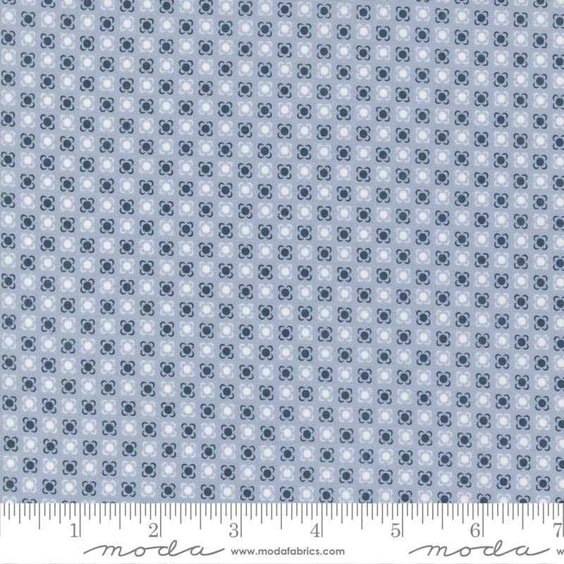 A fabric with a small geometric pattern featuring blue and white colors, displaying the brand name 'moda' on the bottom.