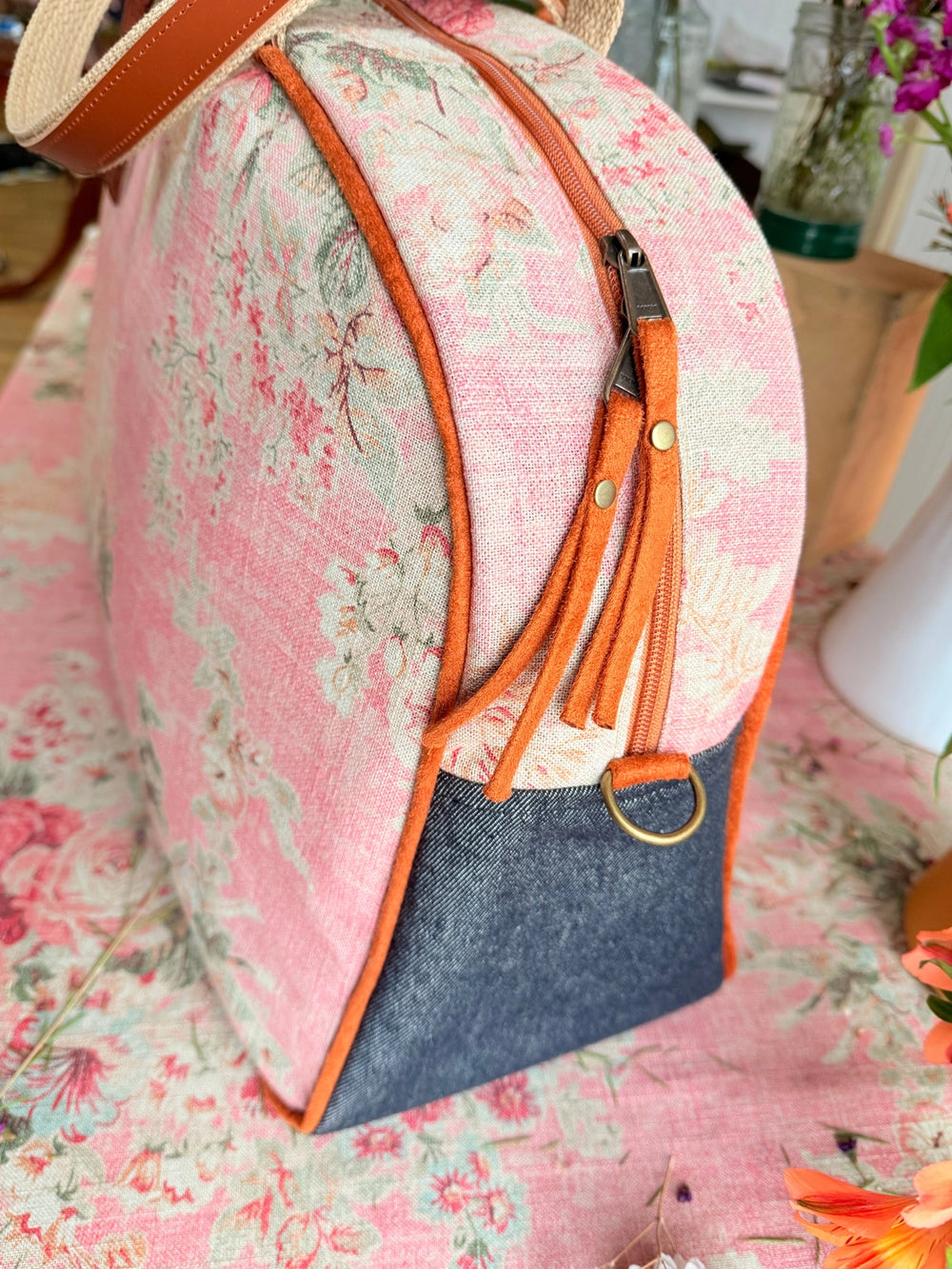 Floral-patterned backpack with orange accents on a floral surface