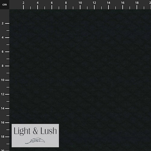 Black fabric swatch with measurement scale and 'Light & Lush' branding.
