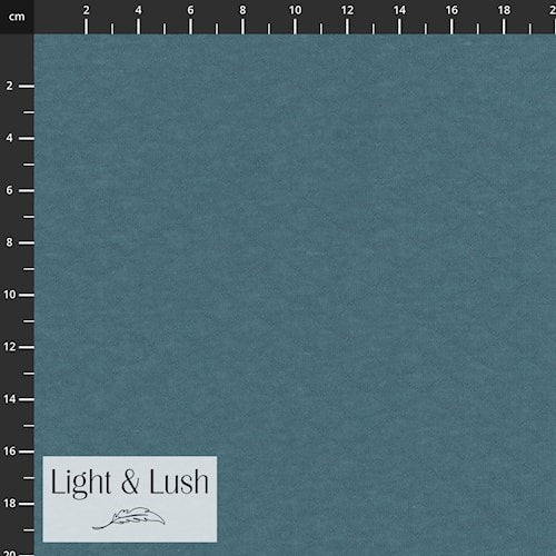 Teal fabric swatch with measurement scale and 'Light & Lush' label