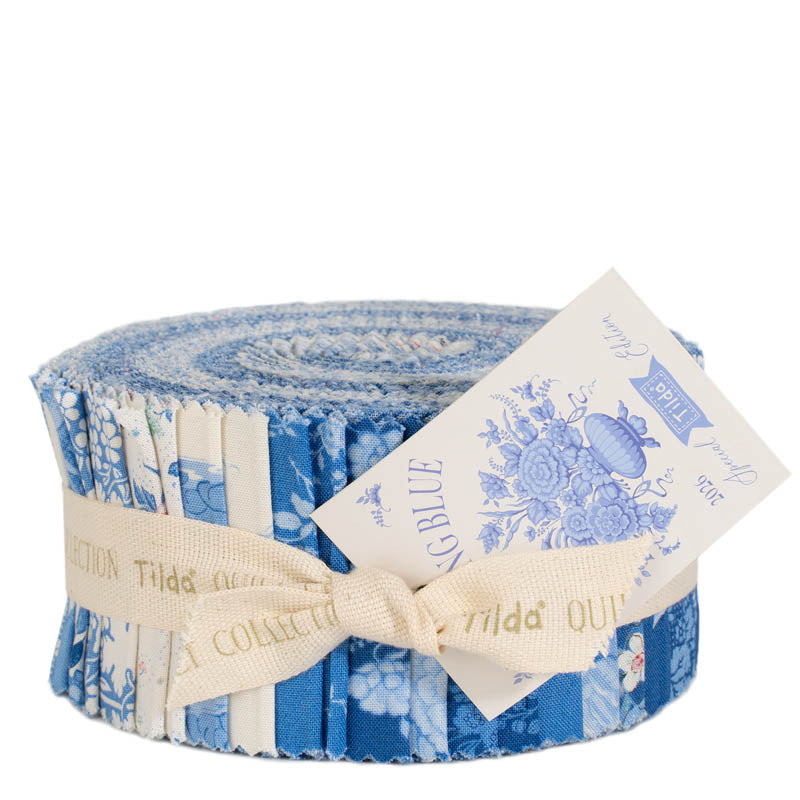Roll of blue floral fabric with a Tilda label on a white background
