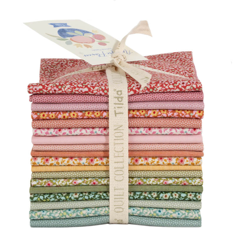 Stack of colorful fabric strips with a Tilda label on a white background