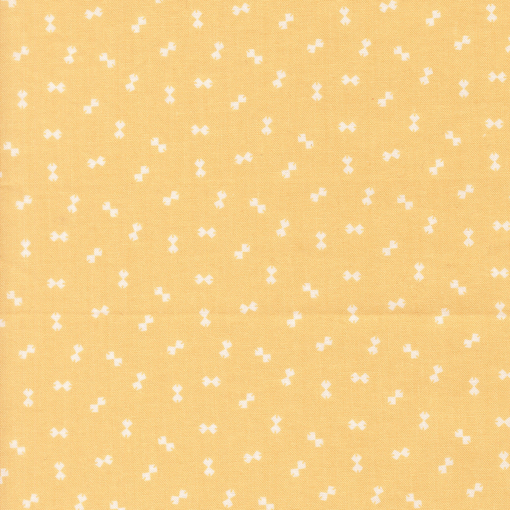 Yellow fabric with small white bow pattern