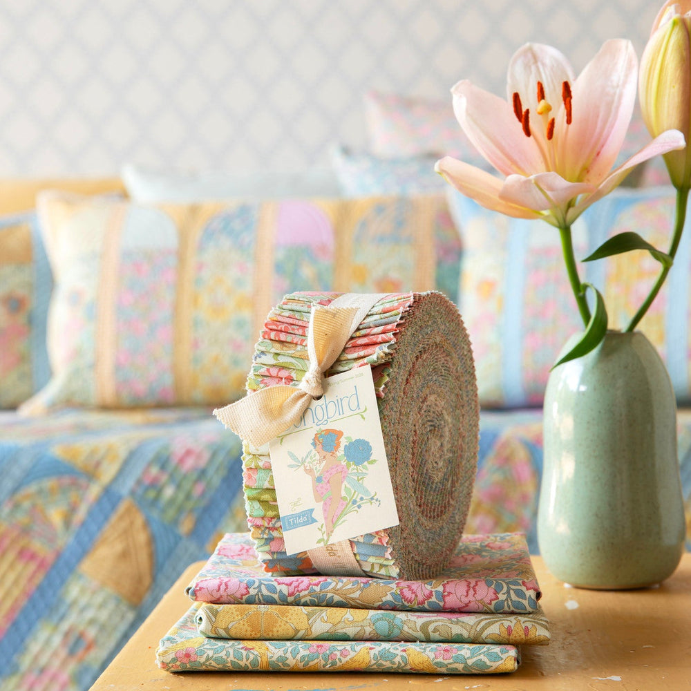 Decorative items on a wooden table with a pastel-colored sofa in the background
