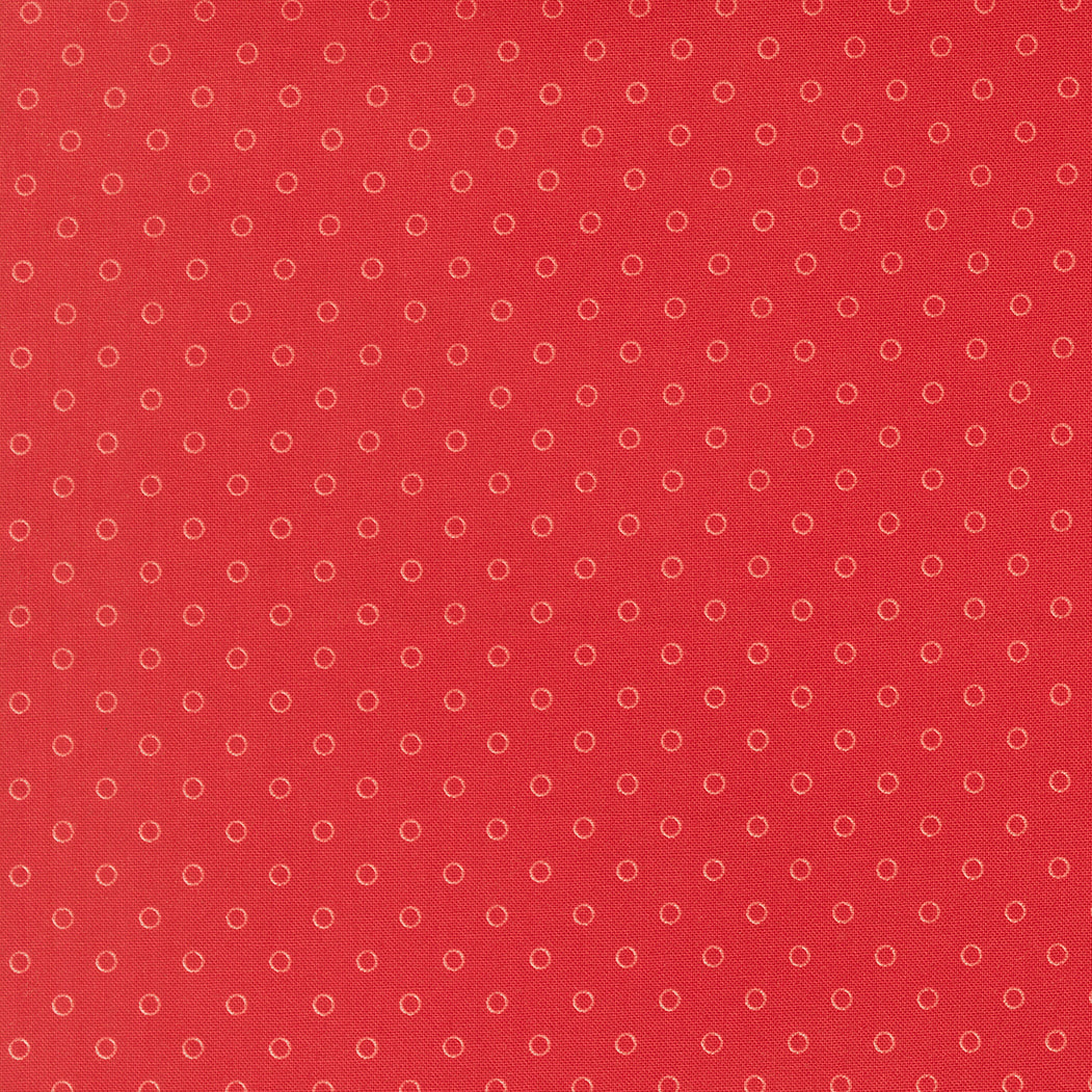Red fabric texture with a subtle pattern of small circles.