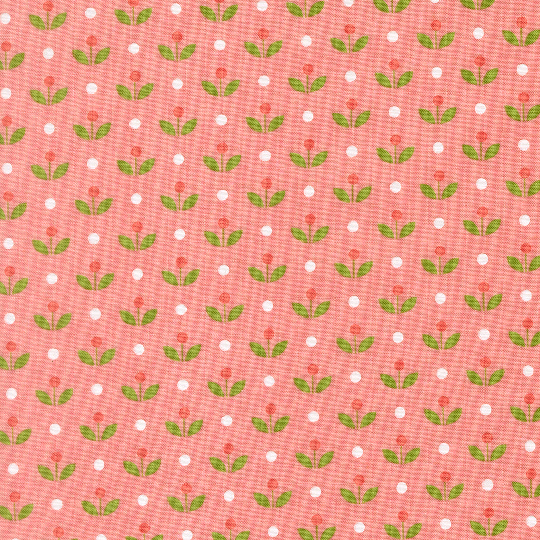 Patterned fabric with red flowers, green leaves, and white polka dots on a pink background