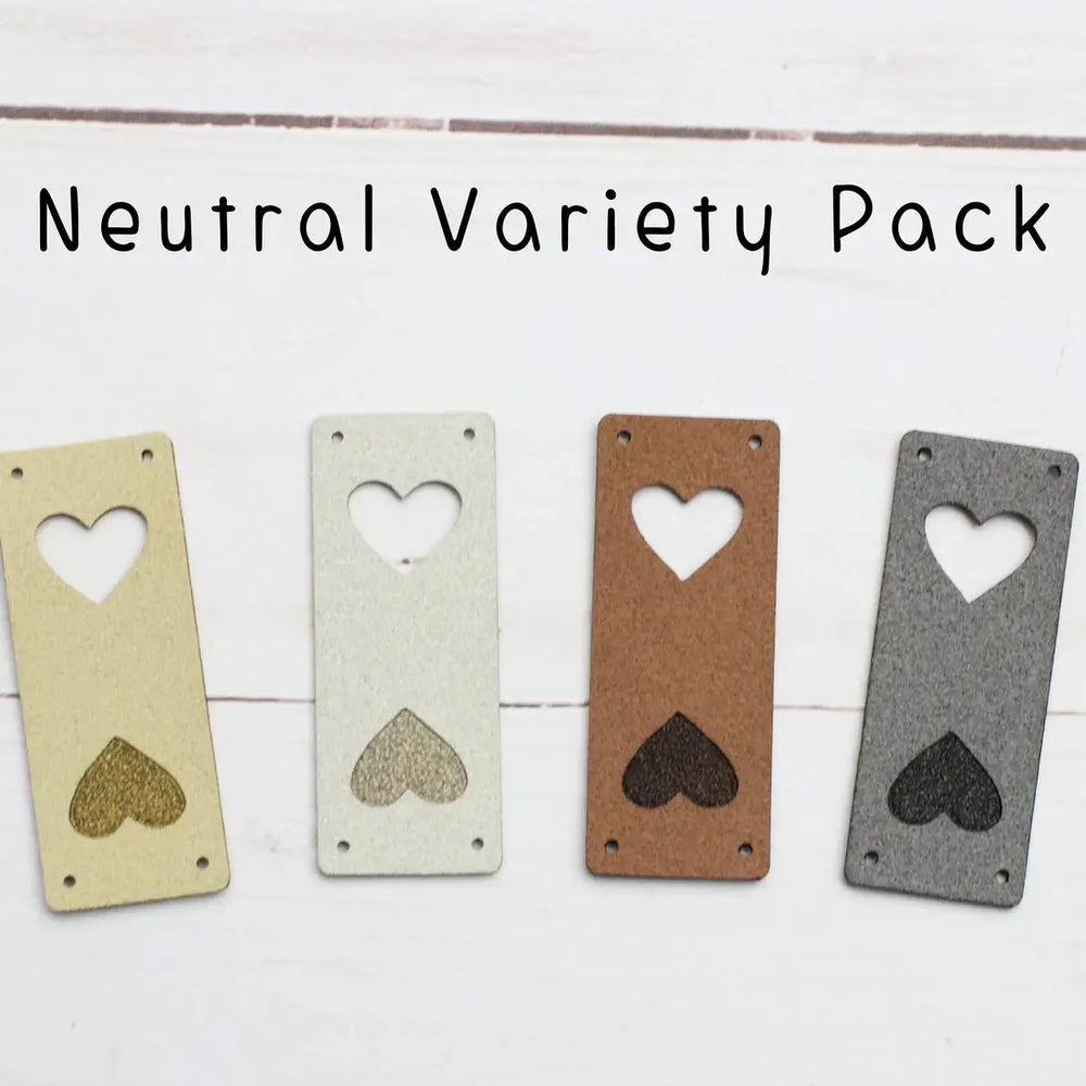 Four heart-shaped metal tags in neutral colors on a white background with text 'Neutral Variety Pack'.