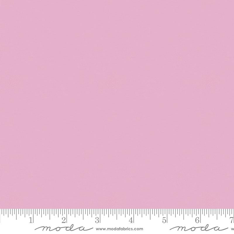 Solid light pink fabric swatch with a ruler at the bottom