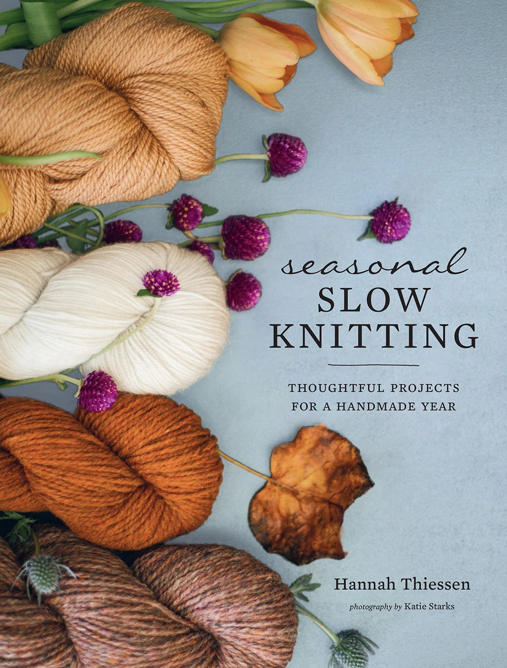 Book cover of 'Seasonal Slow Knitting' with yarn and flowers on a light blue background