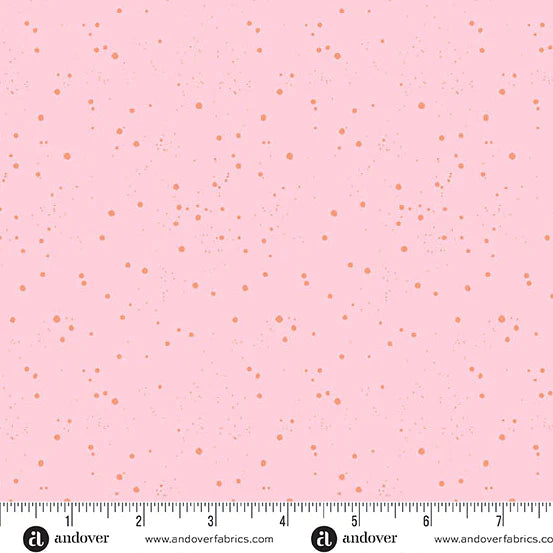Pink fabric with small orange dots and a ruler at the bottom for scale.