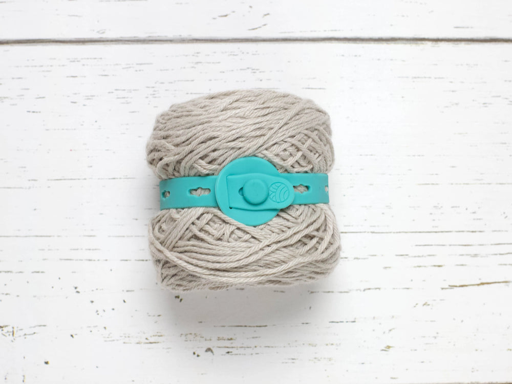 Teal yarn belt around a ball of yarn