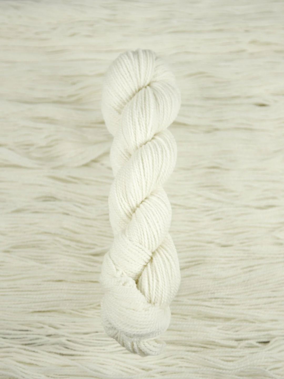 White skein of yarn on a textured white background