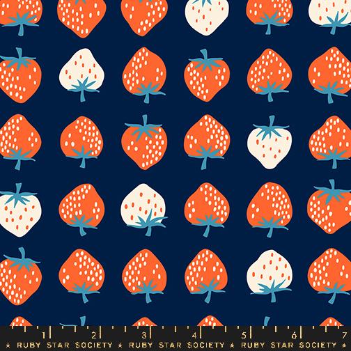 Red and cream colored strawberries on a navy background