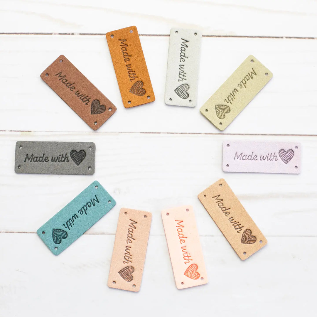 Assorted wooden tags with 'Made with Love' text on a white wooden surface