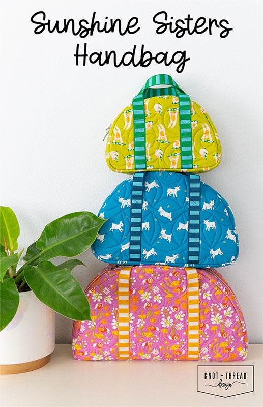 Stack of colorful handbags with 'Sunshine Sisters' text and plant in the background