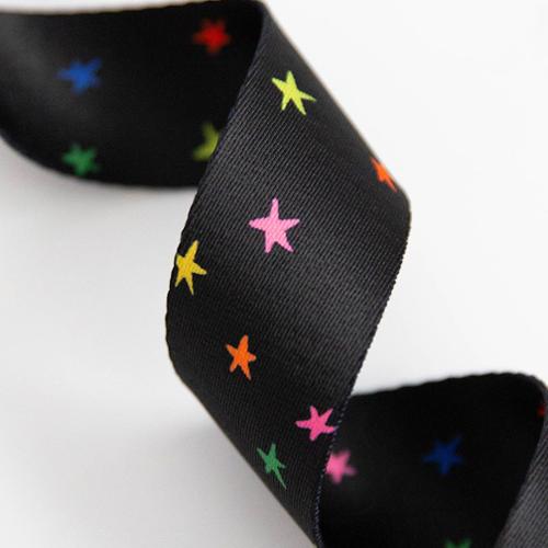 black webbing for bag straps is shown with an array of different colored stars
