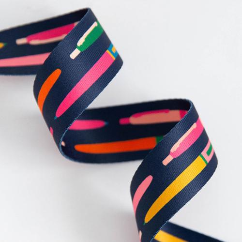 navy blue webbing for bags with a brightly colored prints of pens