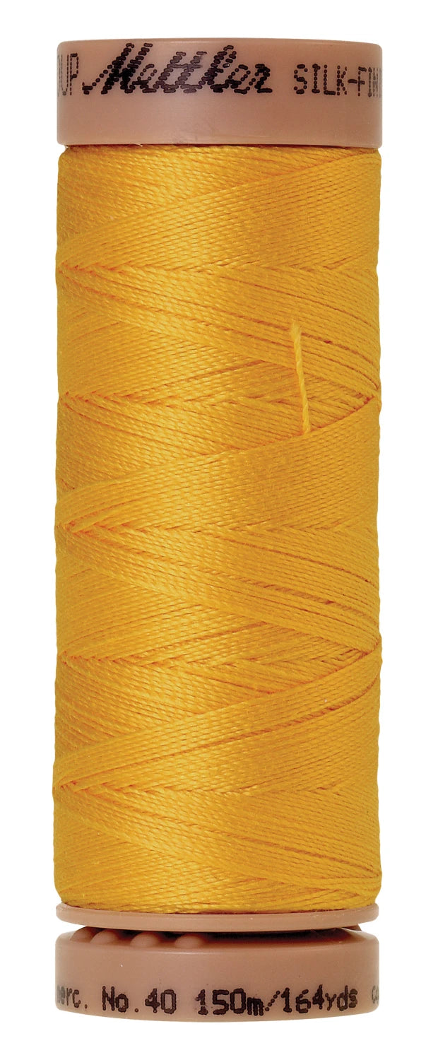 spool of golden yellow thread
