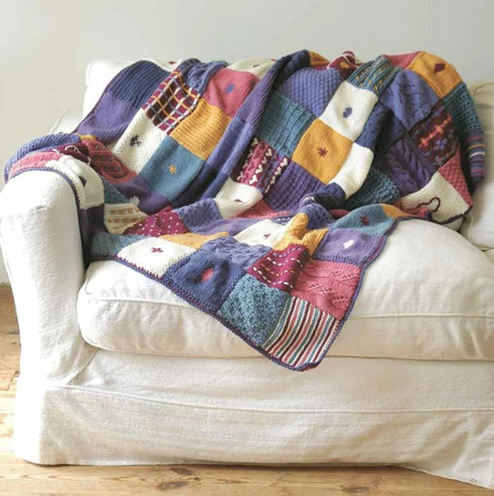 Colorful patchwork blanket draped over a white couch.