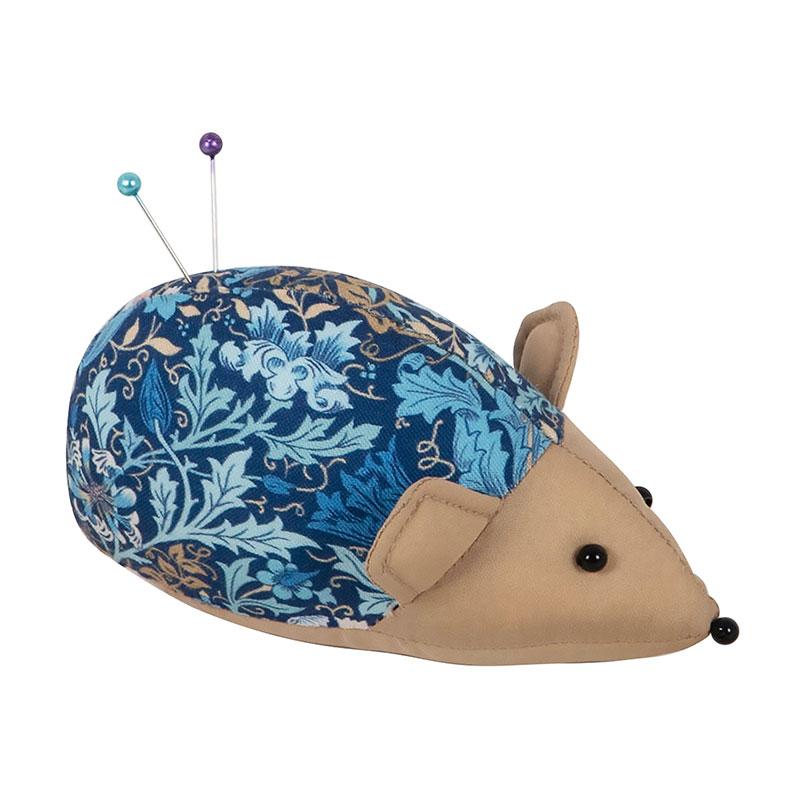 Hedgehog-shaped pin cushion with blue floral pattern on a white background