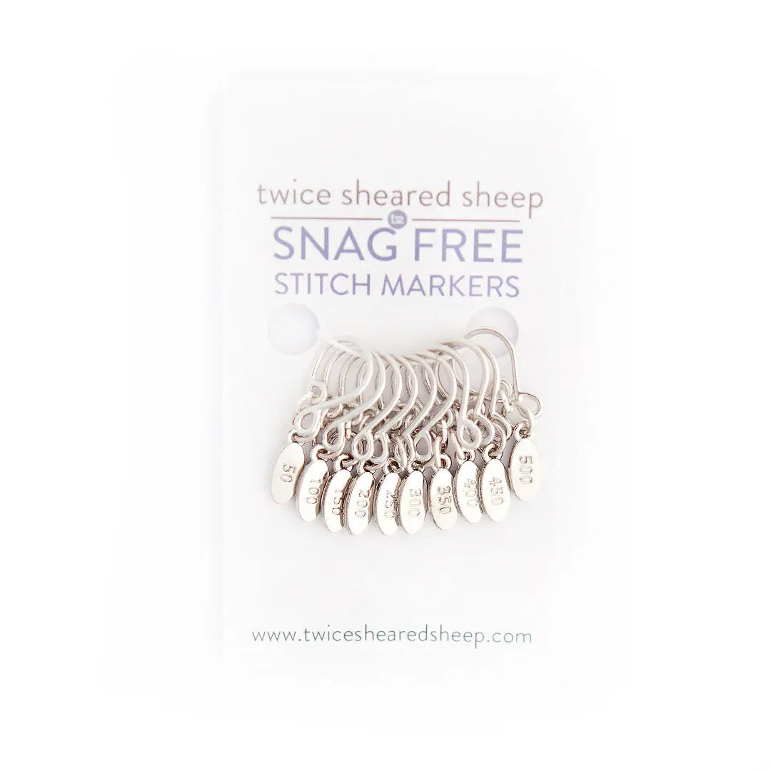 a line of metal stitch markers featuring numbers between 50 and 500, in a package with the title "twice sheared sheep snag free stitch markers" labeled on top
