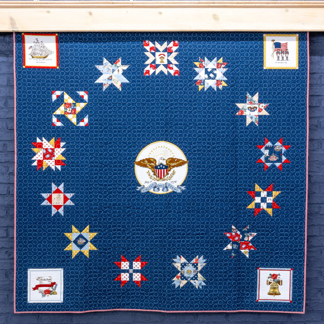 Quilt with star patterns and a central emblem on a blue background