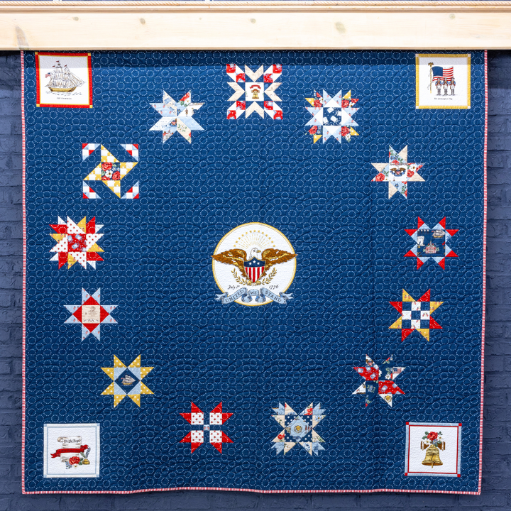 Quilt with star patterns and a central emblem on a blue background