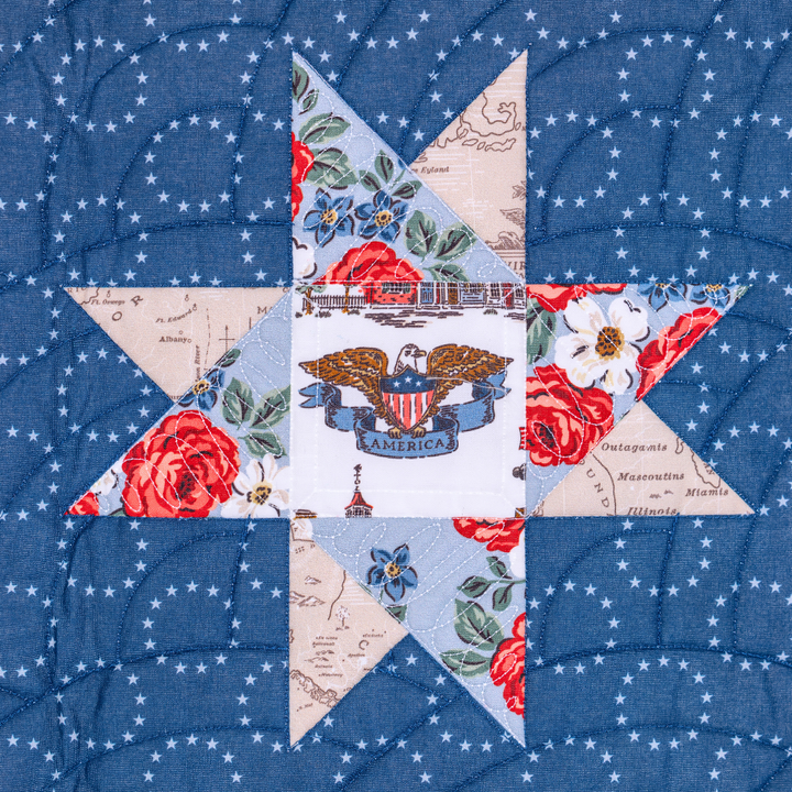 Quilt block with floral and eagle design on a blue background