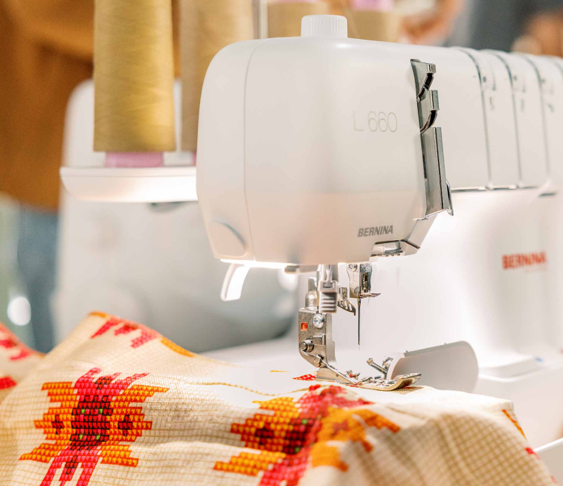 Sewing machine with a colorful fabric on a blurred background