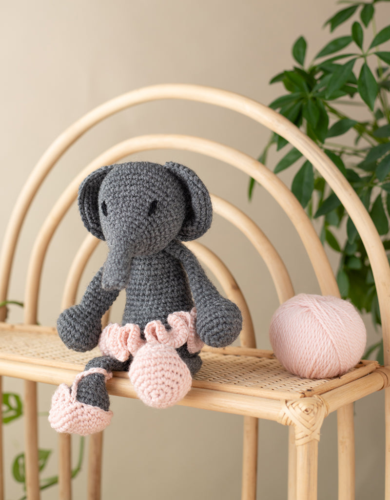 Bridget the Ballerina elephant sitting on a wooden rattan shelf