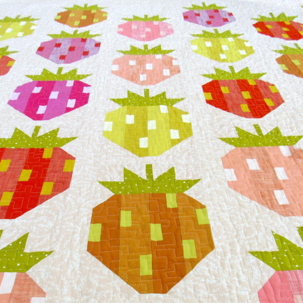Quilt with strawberry pattern on a white background