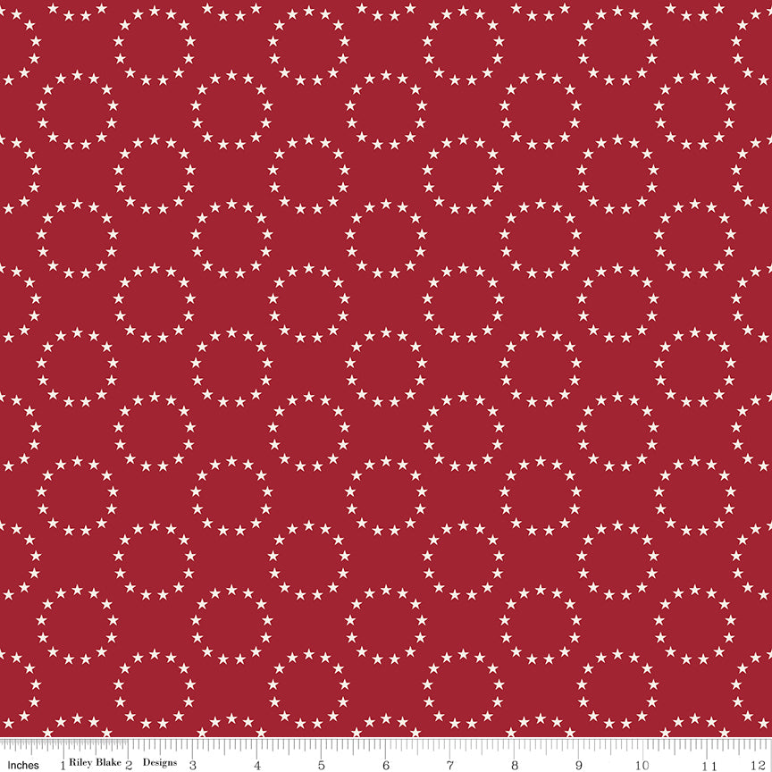 Red fabric with white star patterns and a ruler at the bottom