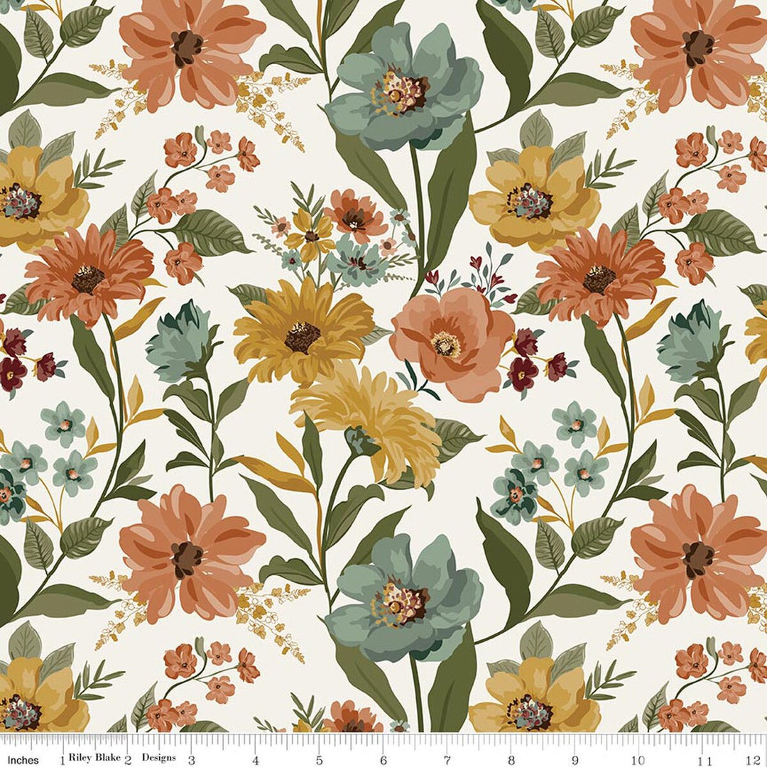 A repeating floral pattern on a white background with large orange, yellow, and teal flowers, green leaves, and small blossoms. A white ruler strip appears along the bottom edge showing scale.