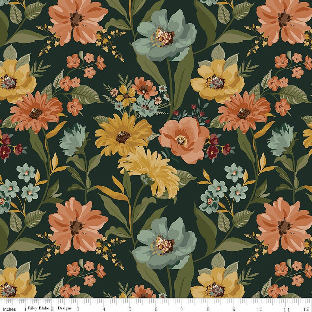 A repeating floral pattern on a warm dark green background with large orange, yellow, and teal flowers, green leaves, and small blossoms. A white ruler strip appears along the bottom edge showing scale.
