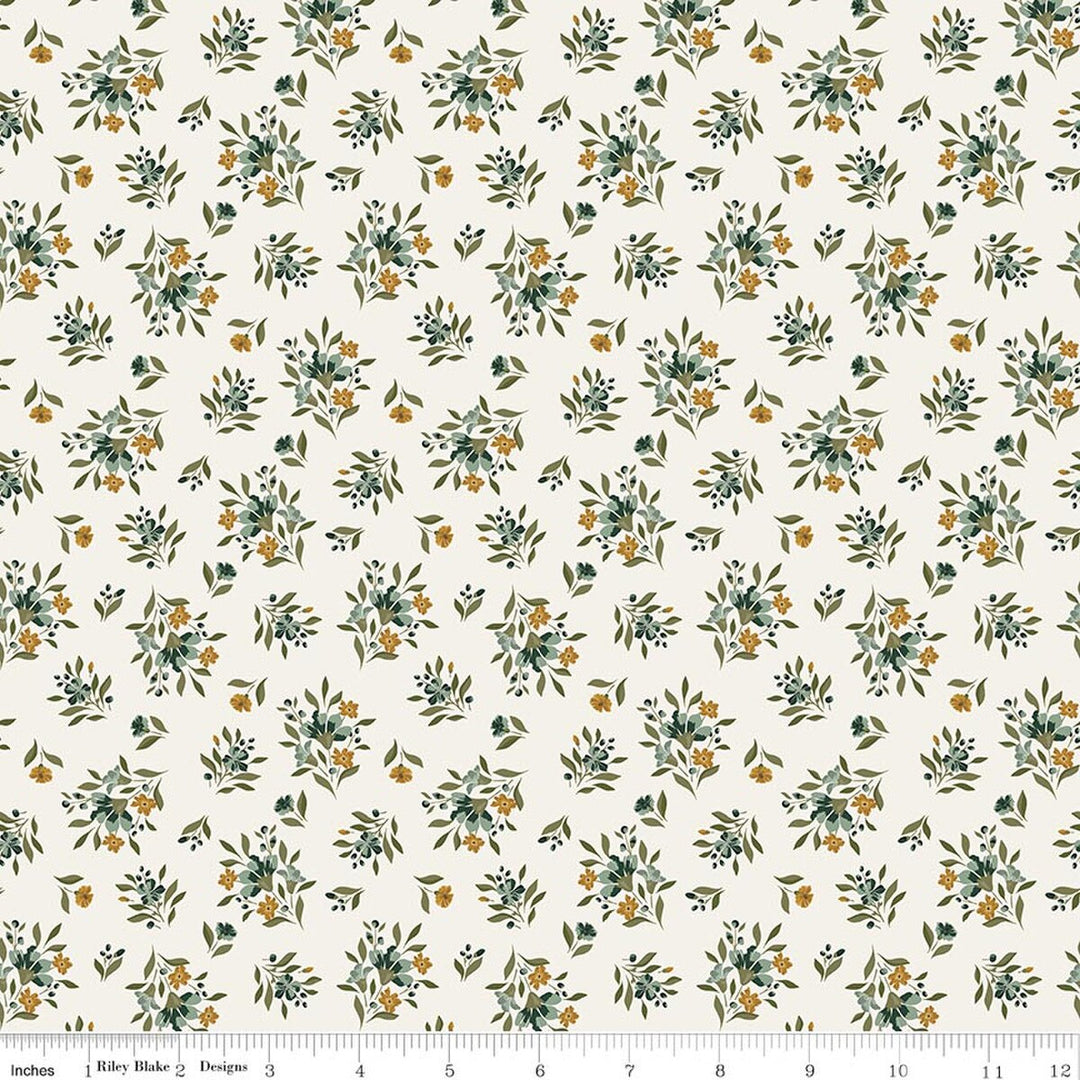 This print features small sprigs of orange and blue flowers and leaves on a warm white background. A white ruler strip appears along the bottom edge showing scale.
