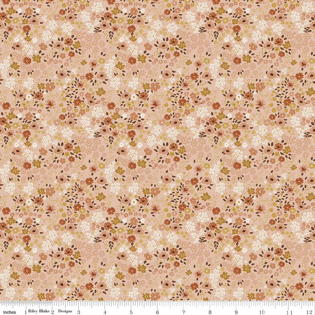This print features small sprigs of rust, white, blush and dark yellow  flowers and leaves on a warm pink background. A white ruler strip appears along the bottom edge showing scale.
