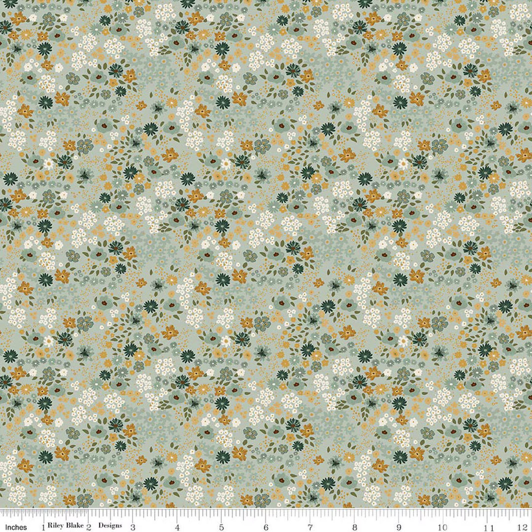 This print features small sprigs of rust, white, blush and green  flowers and leaves on a cool green background. A white ruler strip appears along the bottom edge showing scale.