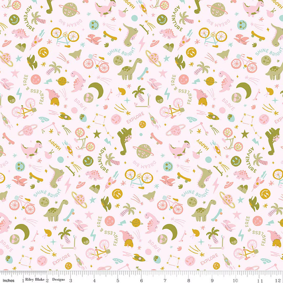 A repeating fabric pattern featuring cute dinosaur, moon, star, and constellation motifs in pink, sage green, and light blue on a white background, with a ruler along the bottom edge showing scale.